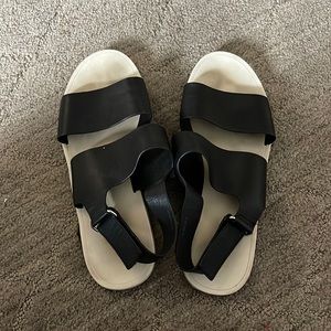 Flat Vince black slides with velcro ankle strap behind ankle